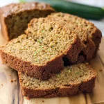 gluten free zucchini bread loaf sliced on a light cutting board